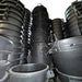Stacks of large black plastic containers in a warehouse setting