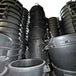 Stacks of large black plastic containers in a warehouse setting