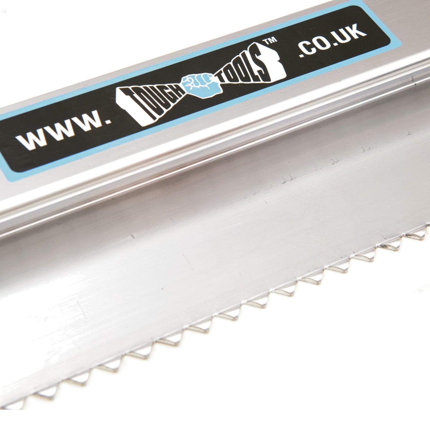 close up of metal plastering tool with serrated teeth