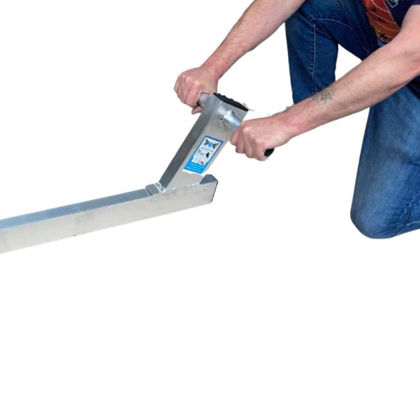Man kneeling down holding the metal straight edge tool handles