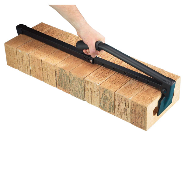 Stack of bricks being held using a black metal tool, held by a hand